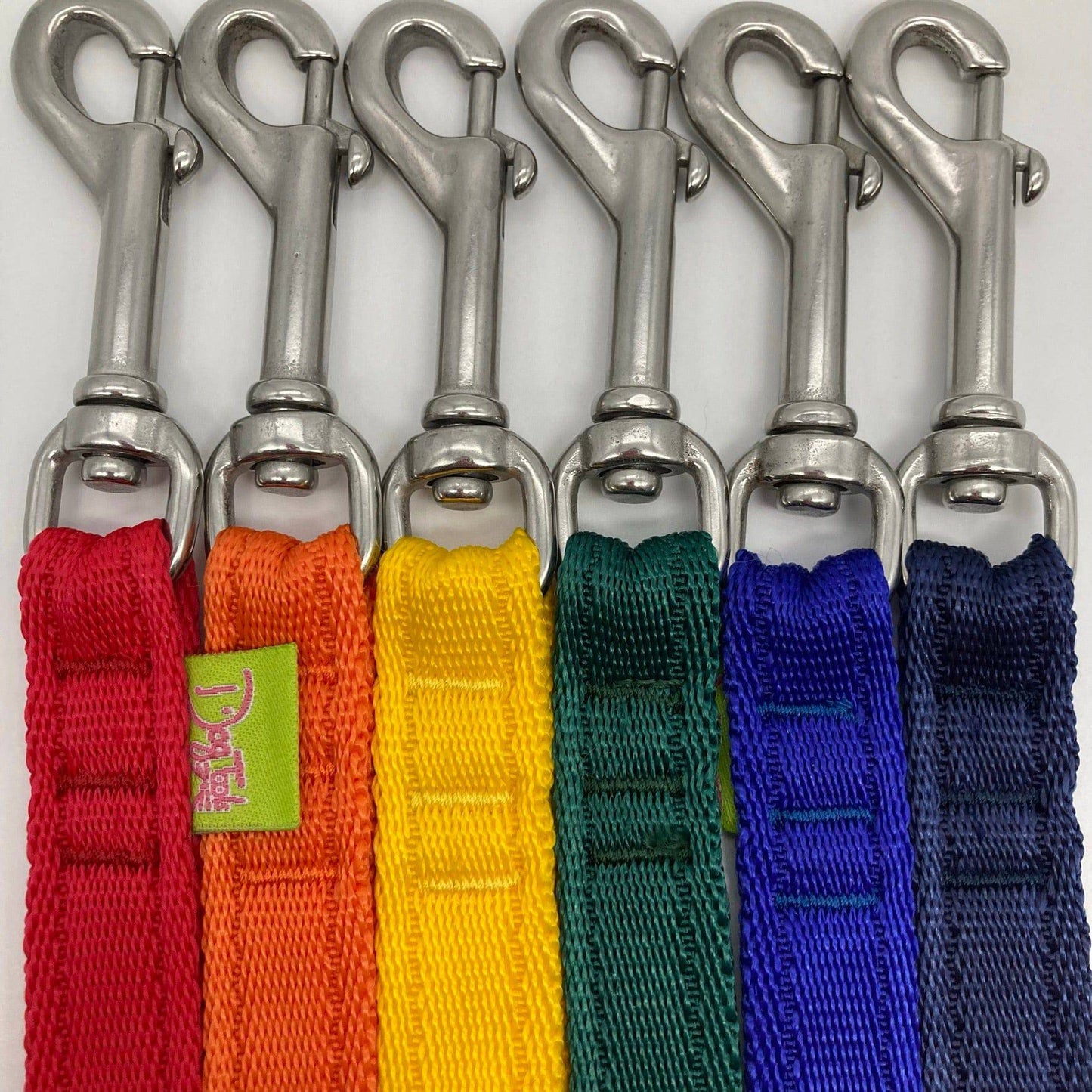 6 DogTools leashes laying next to each other vertically, showing the stainless steel hooks (colors red, orange, yellow, green, blue, dark blue)