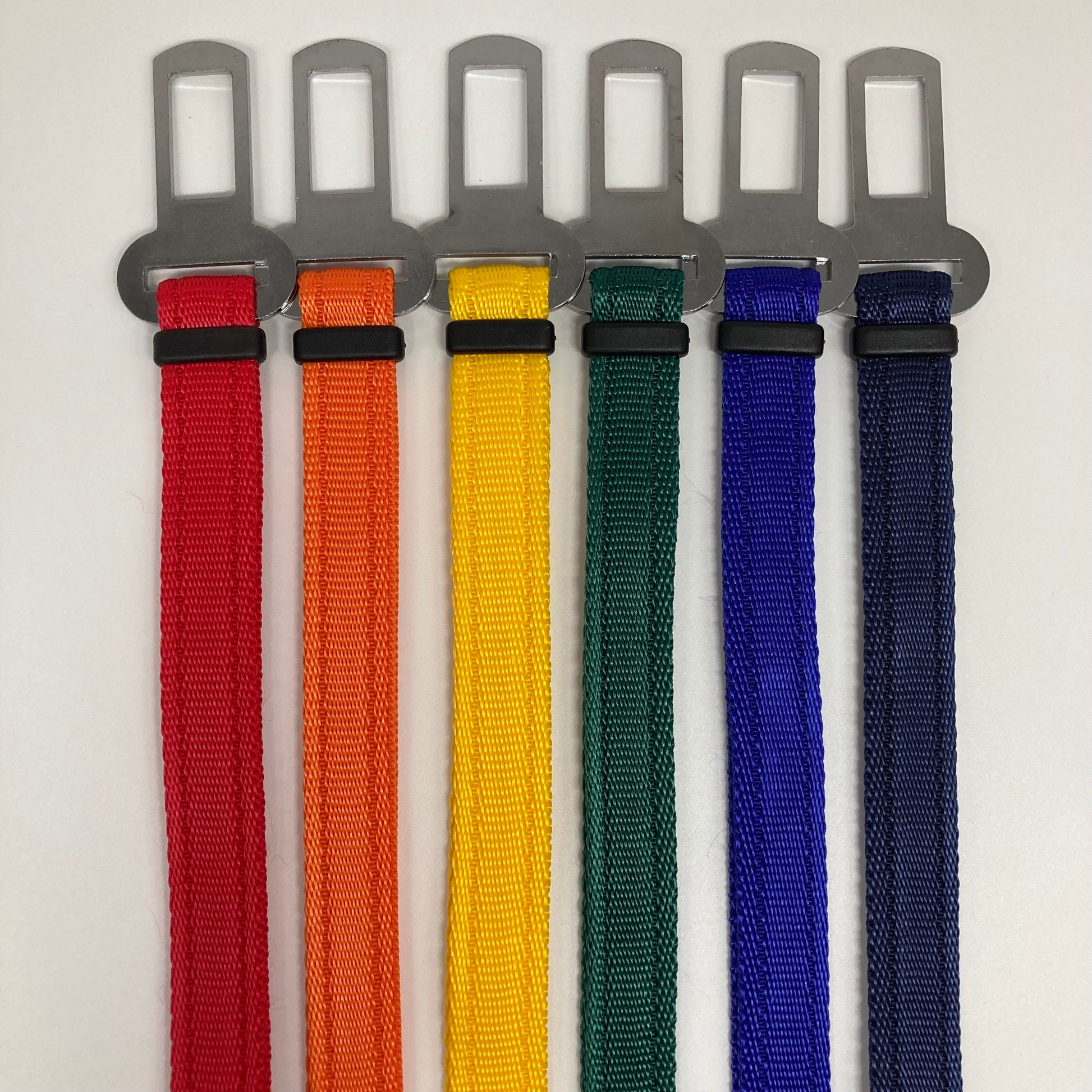 6 car safety belts,  in different colors (red, orange, yellow, green, blue, dark blue), showing vertically next to each other with the stainless steel buckles