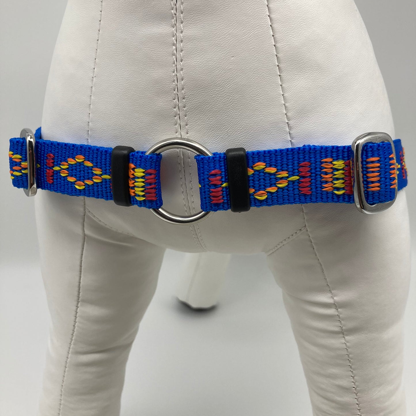 blue Stitch (blue fabric with print in 3 colors, red, yellow and orange) harness, showing the chest from the front, the stainless steel ring where the leash is attached to