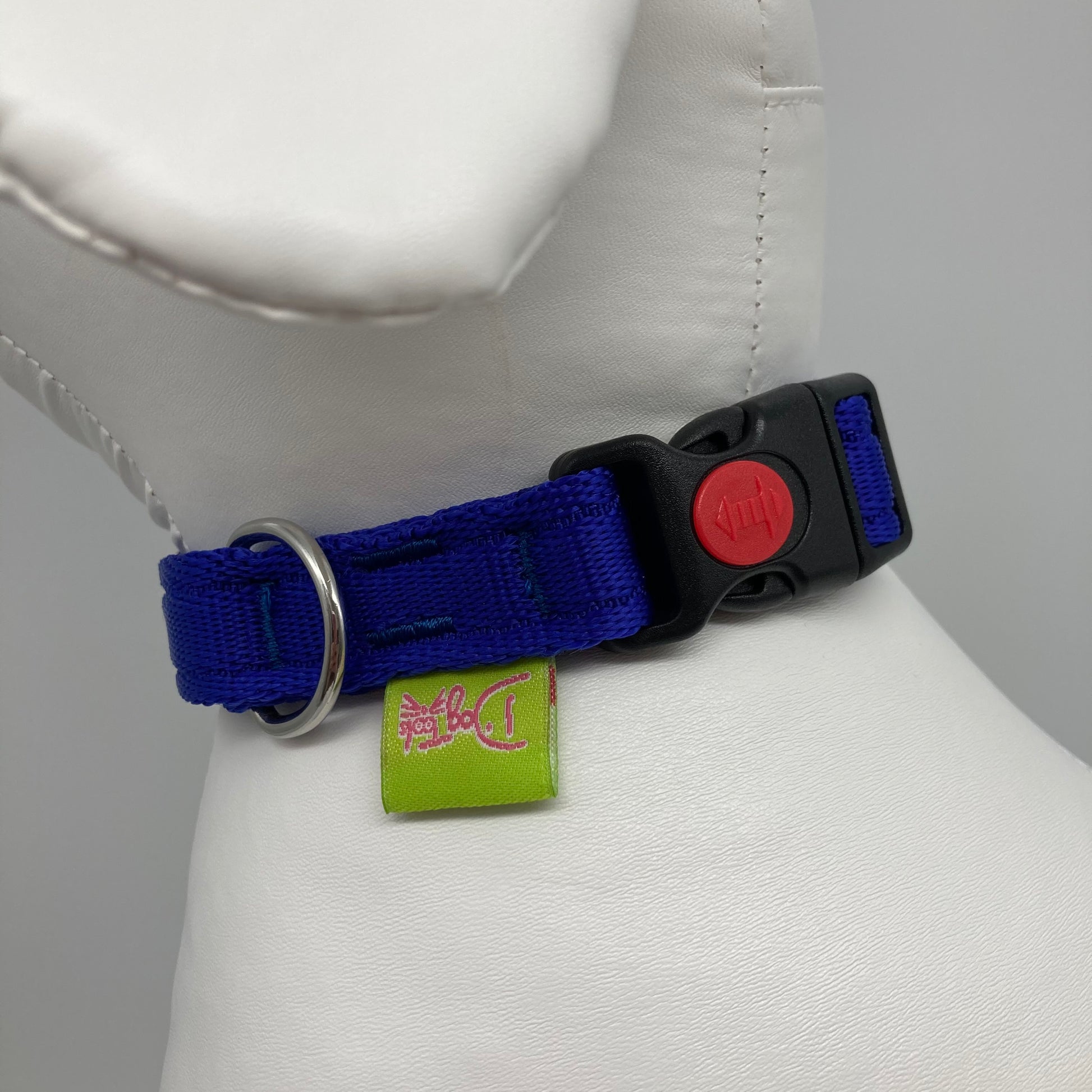 blue collar showing the black lock, stainless steel ring and the applegreen label with DogTools logo on it. Displayed on a stuffed toy (dog), around the neck