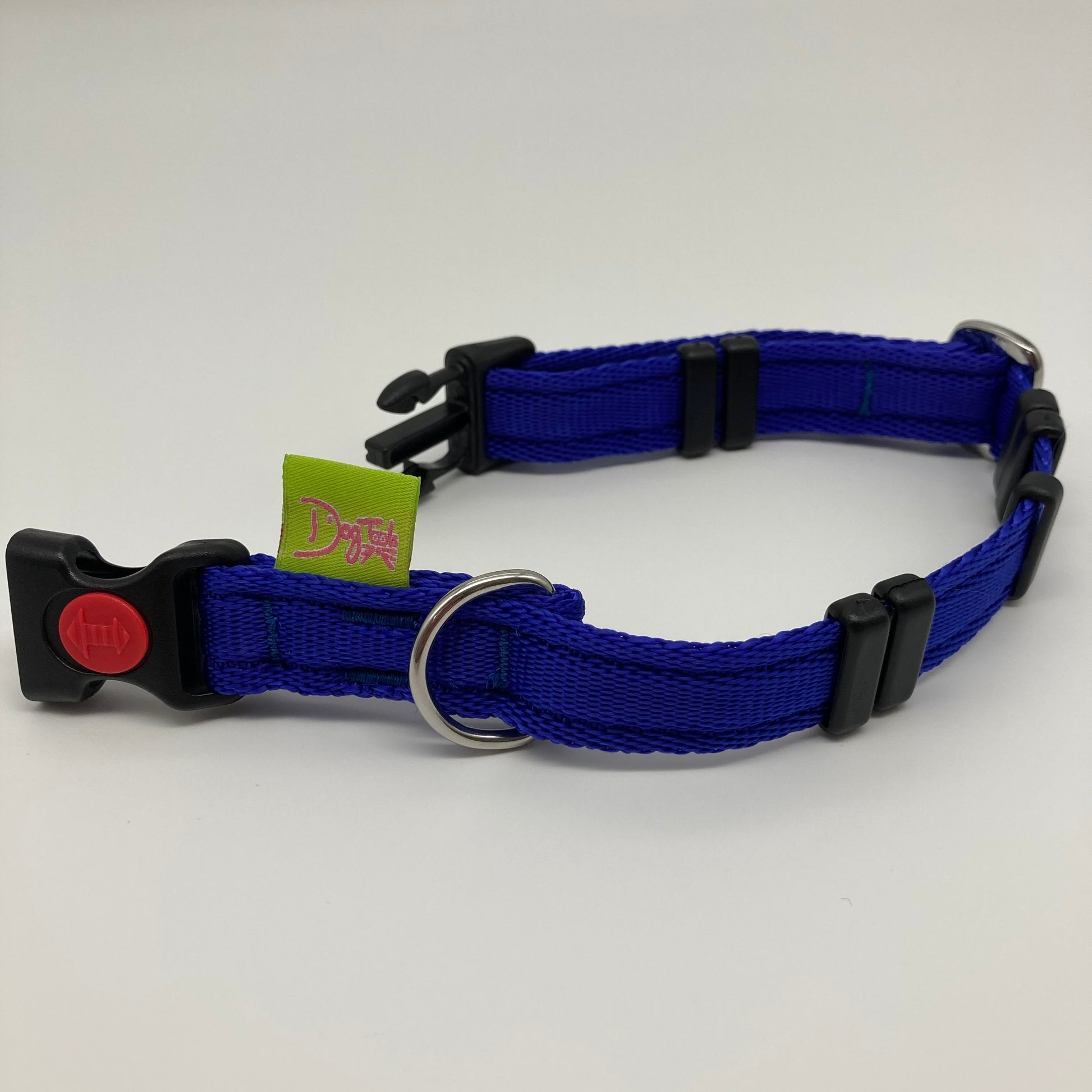 blue collar displayed on a white surface, unlocked, showing the black lock, stainless steel ring, the black loops and the applegreen DogTools label