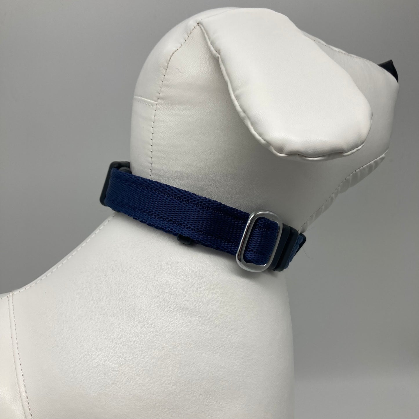 dark blue collar displayed on a stuffed toy (dog), showing the back of the head and the collar from behind