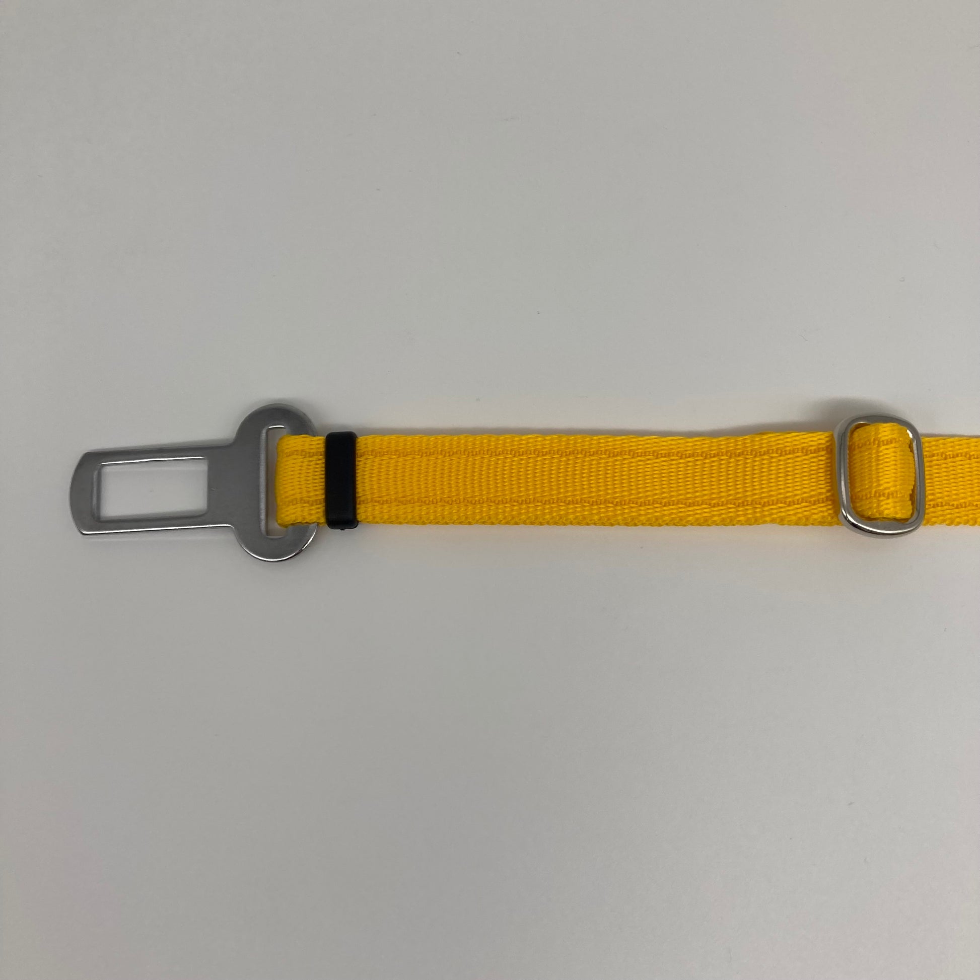 yellow car safety belt, showing the stainless steel buckle and the stainless steel clasp to adjust the length of the belt