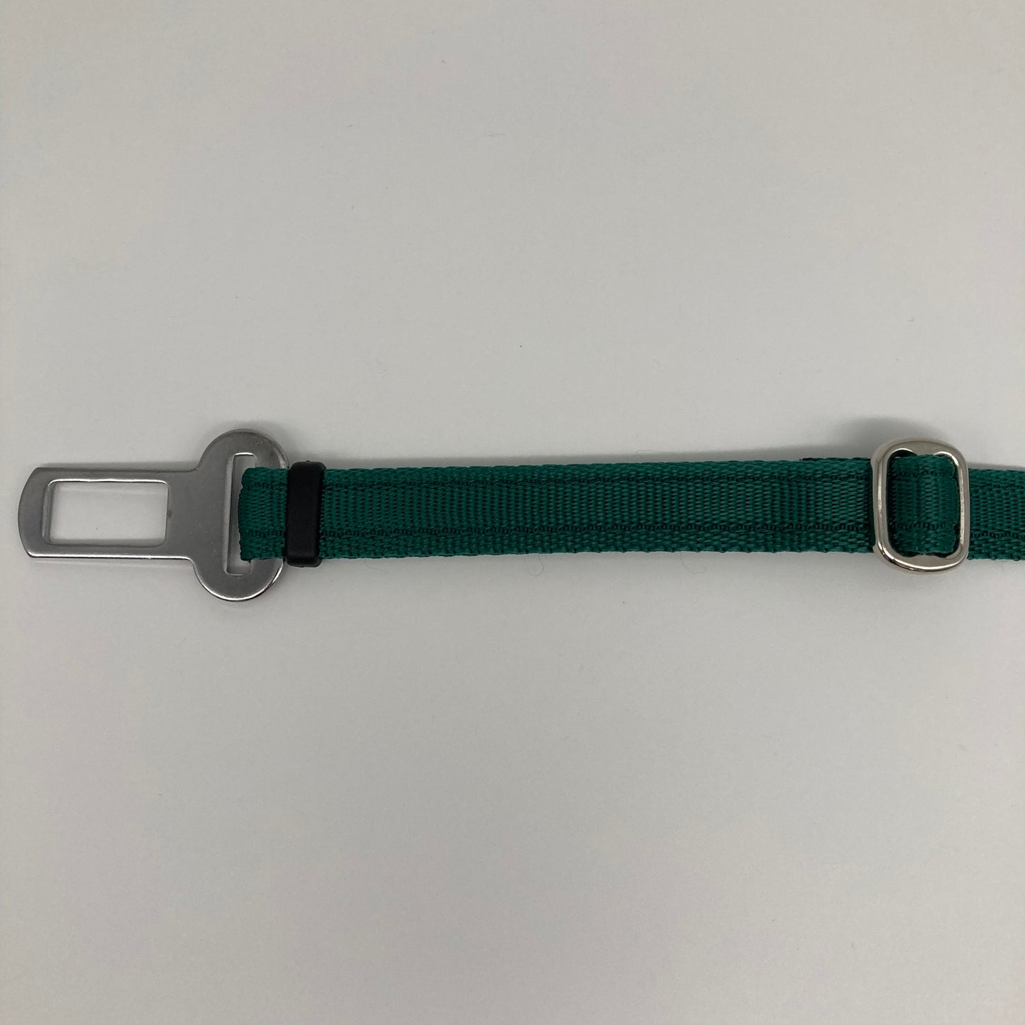 green car safety belt, showing the stainless steel buckle and the stainless steel clasp to adjust the length of the belt