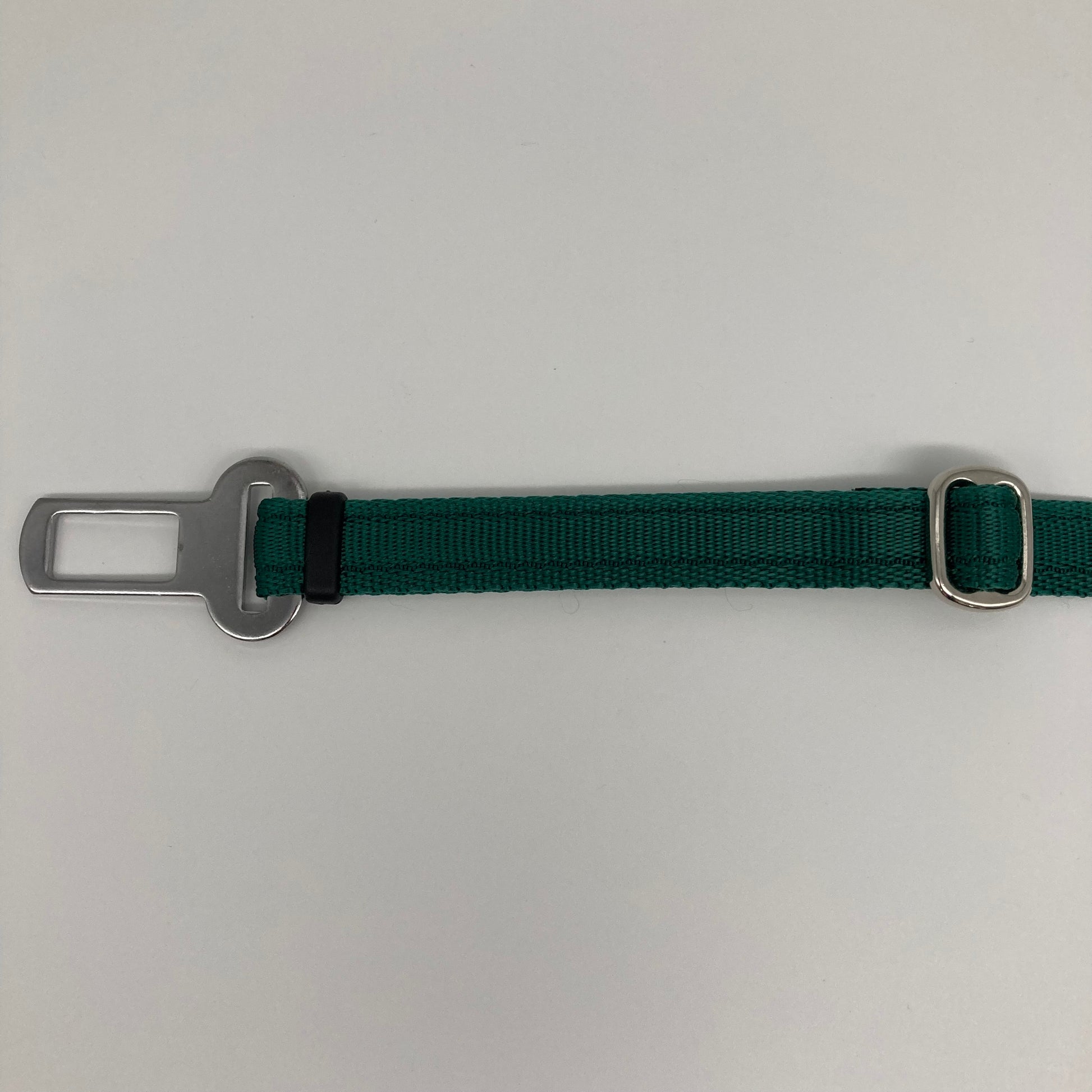 green car safety belt, showing the stainless steel buckle and the stainless steel clasp to adjust the length of the belt