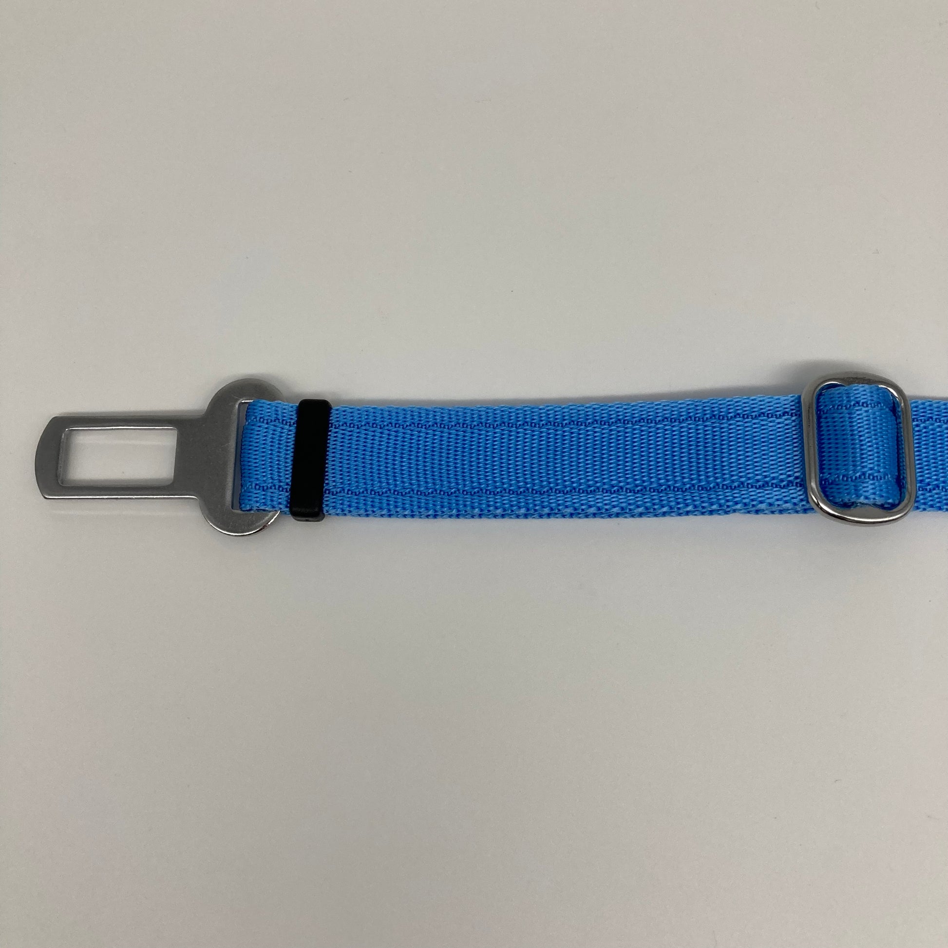 light blue car safety belt, showing the stainless steel buckle and the stainless steel clasp to adjust the length of the belt