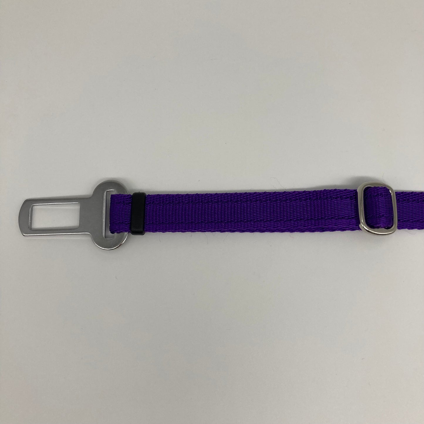 purple car safety belt, showing the stainless steel buckle and the stainless steel clasp to adjust the length of the belt