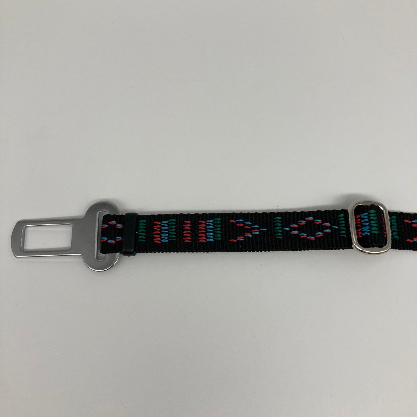 black Stitch (black fabric with print in 3 colors, red, light blue and green) car safety belt, showing the stainless steel buckle and the stainless steel clasp to adjust the length of the belt