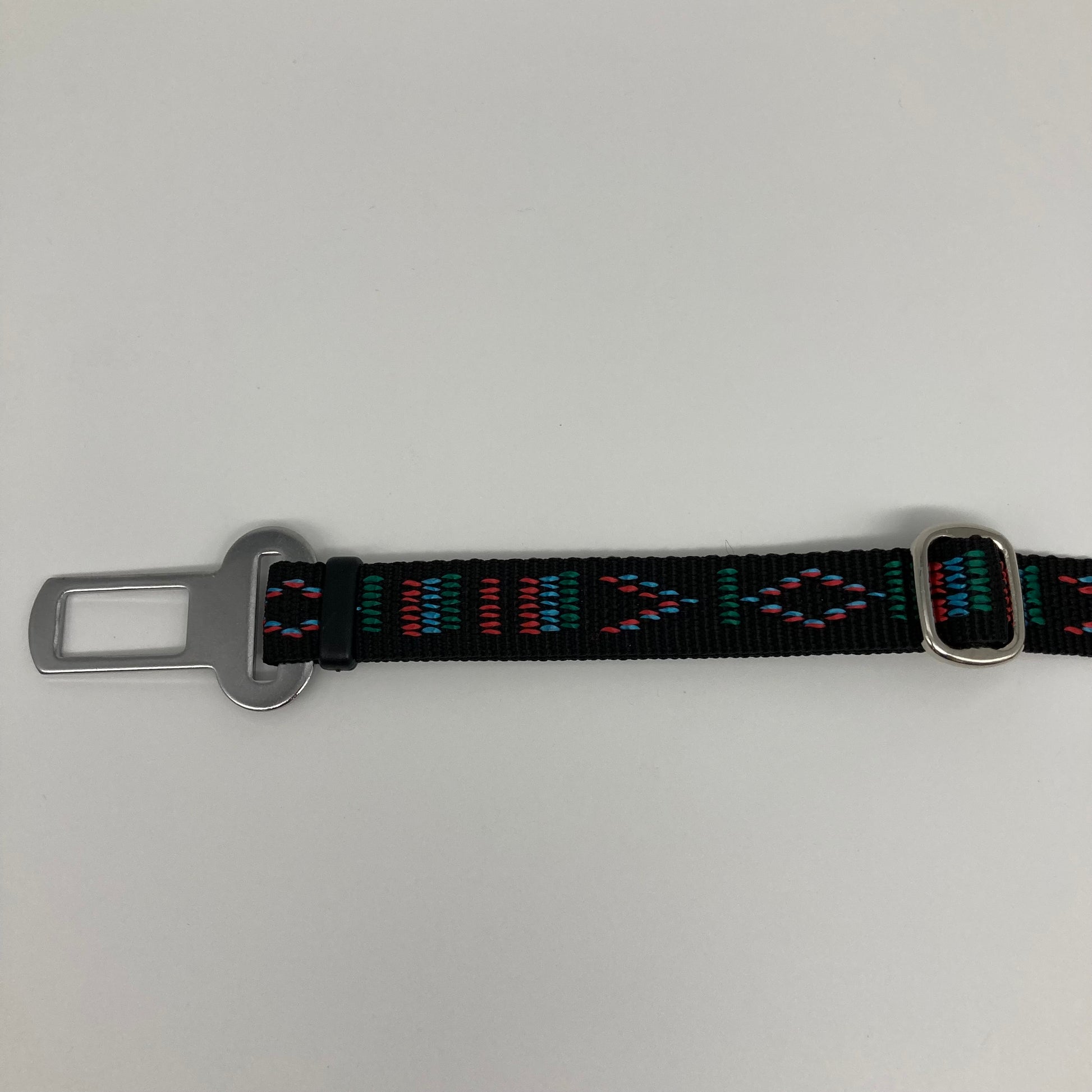 black Stitch (black fabric with print in 3 colors, red, light blue and green) car safety belt, showing the stainless steel buckle and the stainless steel clasp to adjust the length of the belt
