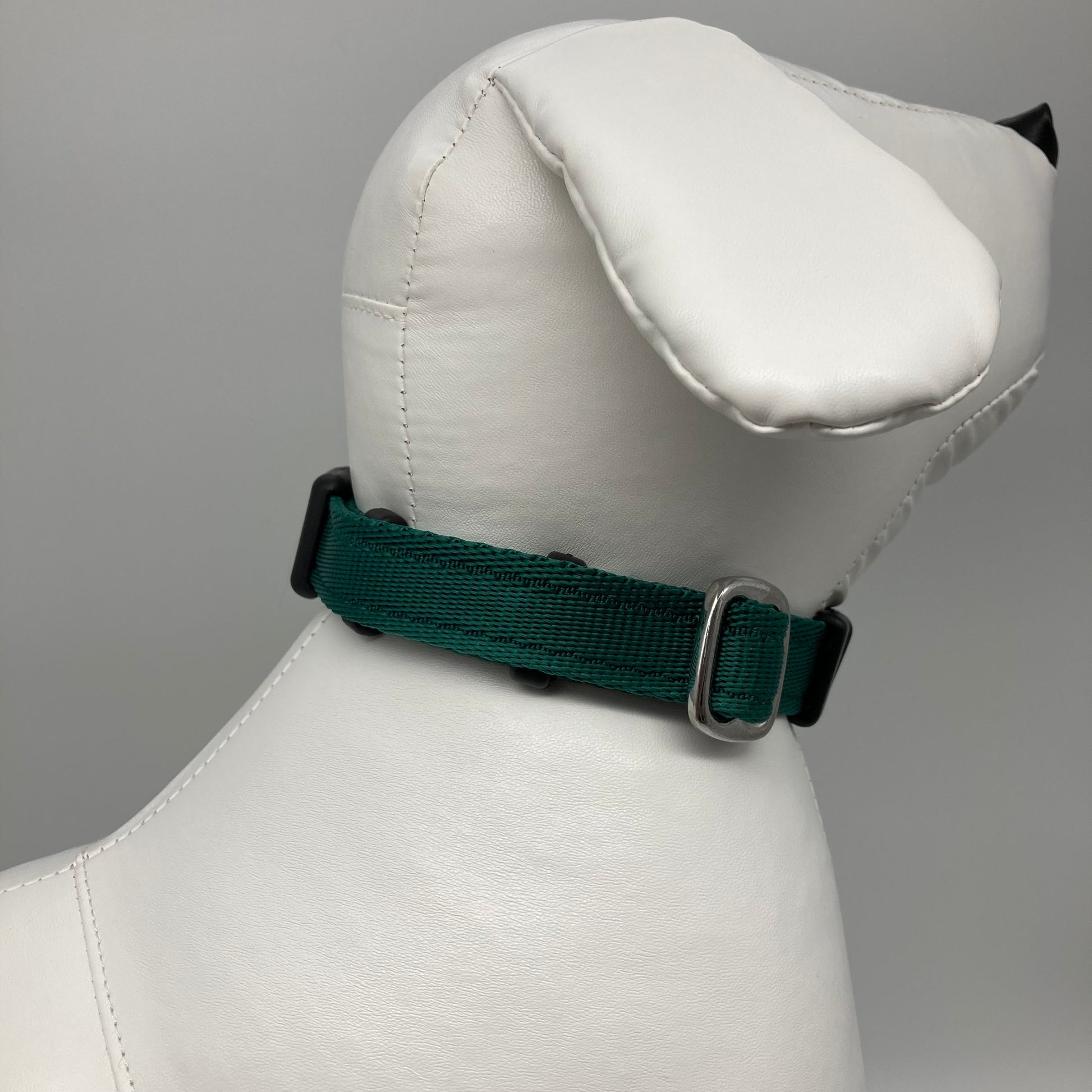 green collar displayed on a stuffed toy (dog), showing the back of the head and the collar from behind