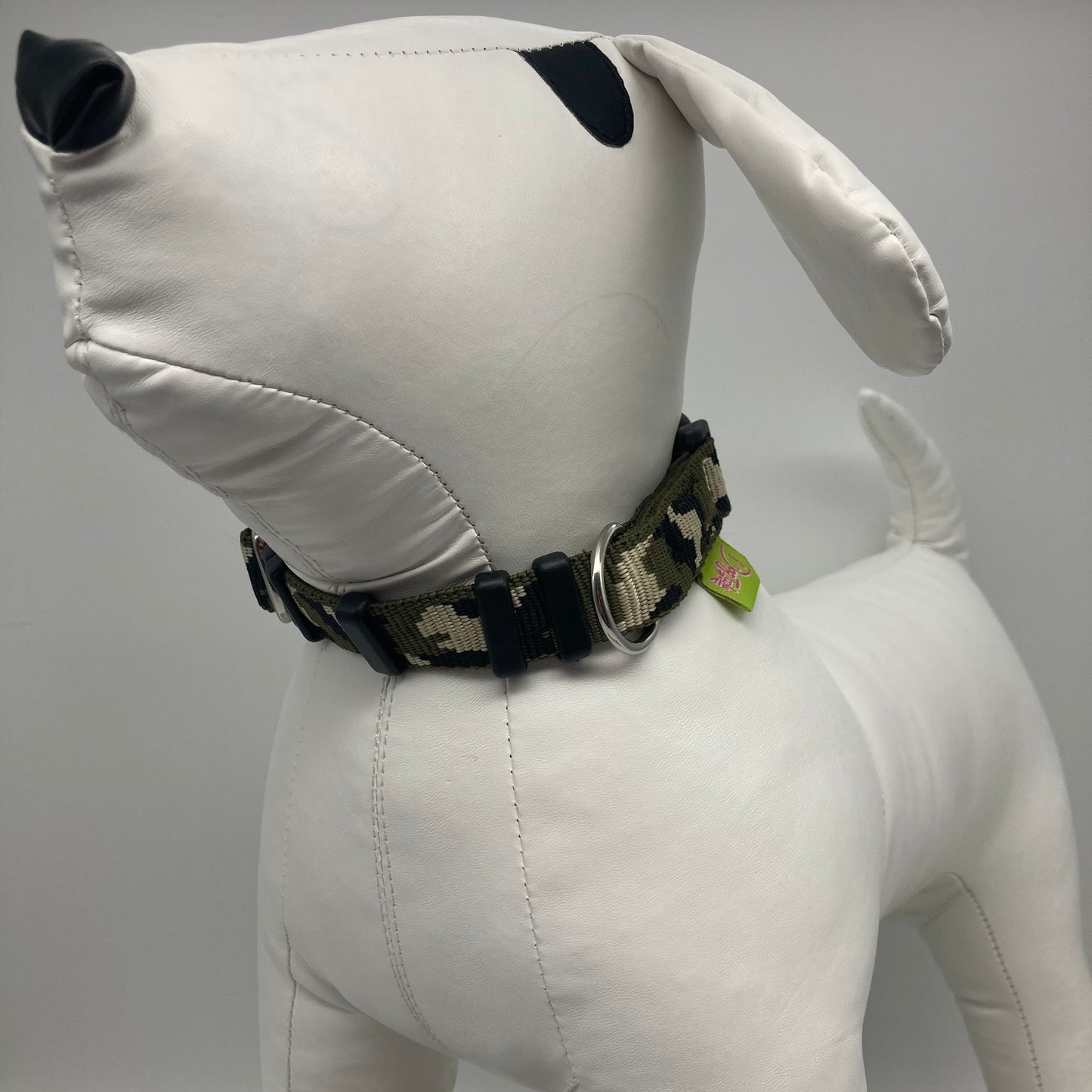 army green (army print in 3 colors, olive green, beige and black) collar displayed on a stuffed toy (dog), from the front of the dog, showing its head and torso