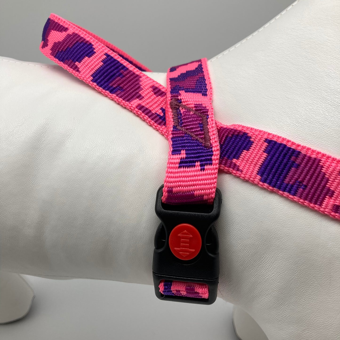 army pink (army print in 3 colors, fushia, purple and pink) harness, displayed on a stuffed toy (dog), around the torso, showing the black lock and the loop on the back