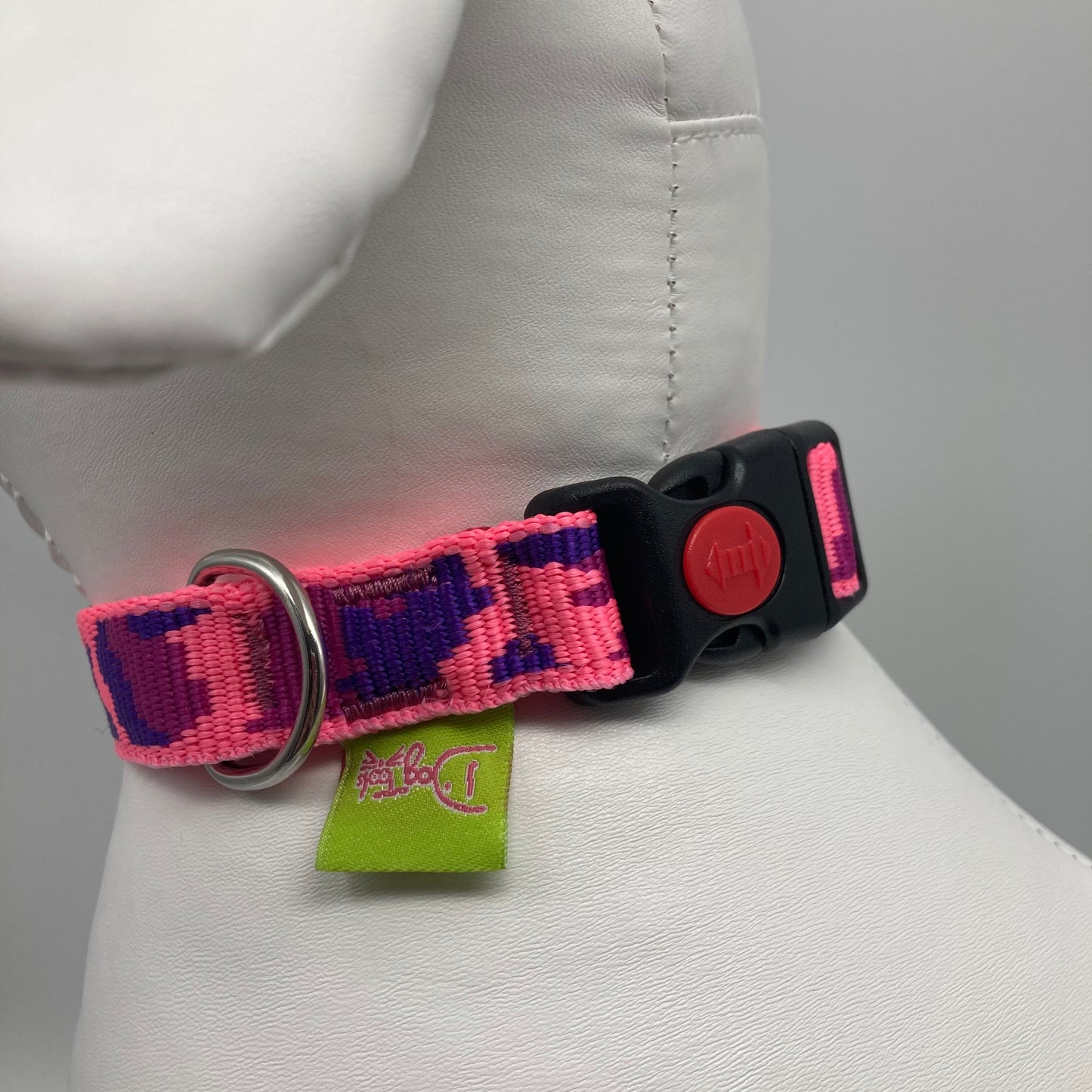 army pink (army print in 3 colors, fushia, purple and pink) collar showing the black lock, stainless steel ring and the applegreen label with DogTools logo on it. Displayed on a stuffed toy (dog), around the neck