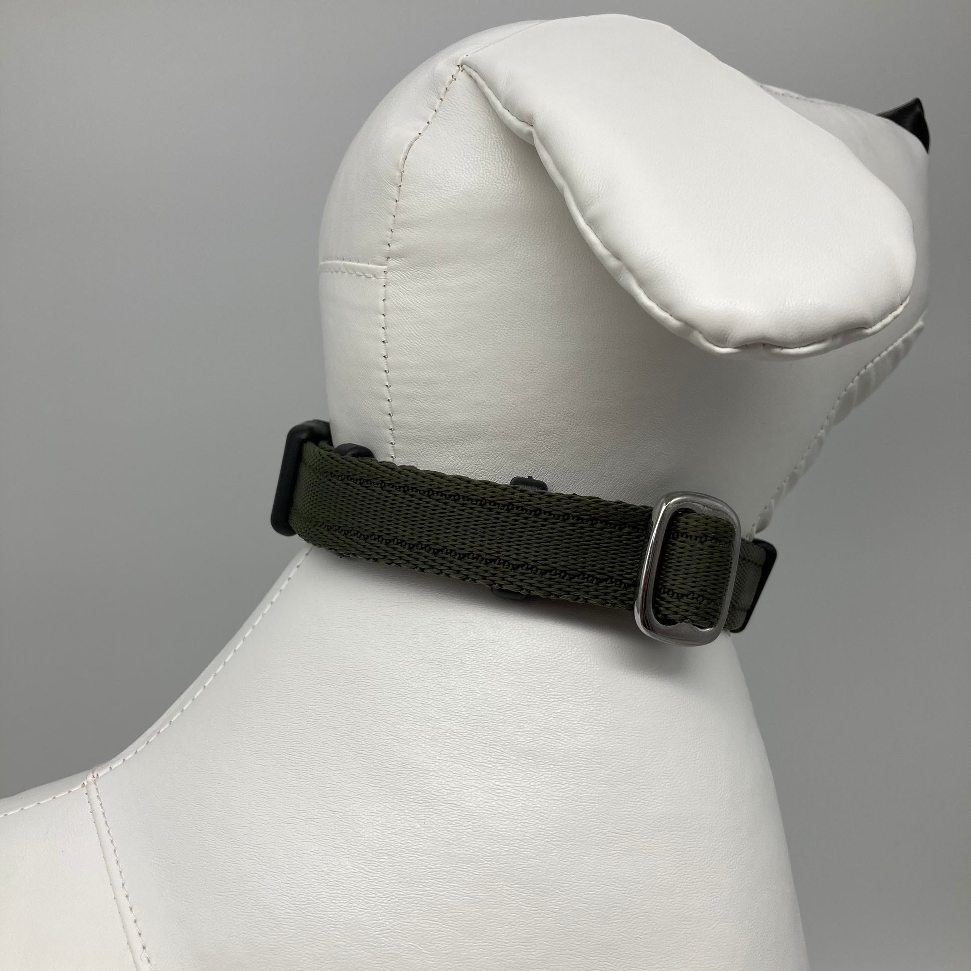 olive green collar displayed on a stuffed toy (dog), showing the back of the head and the collar from behind