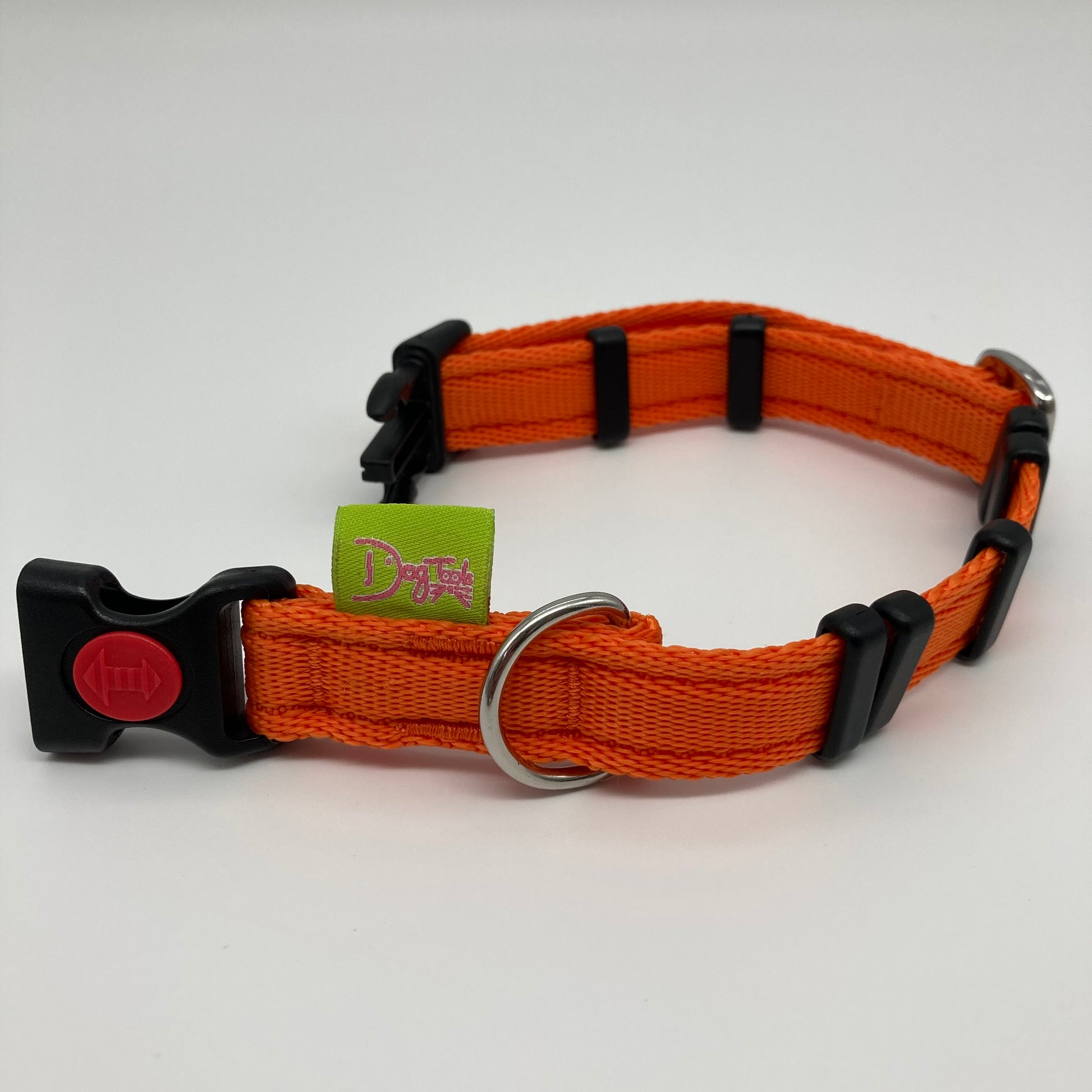 orange collar displayed on a white surface, unlocked, showing the black lock, stainless steel ring, the black loops and the applegreen DogTools label