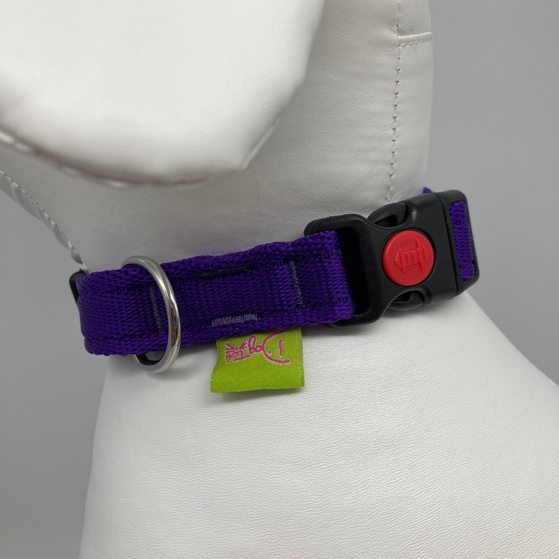 purple collar showing the black lock, stainless steel ring and the applegreen label with DogTools logo on it. Displayed on a stuffed toy (dog), around the neck