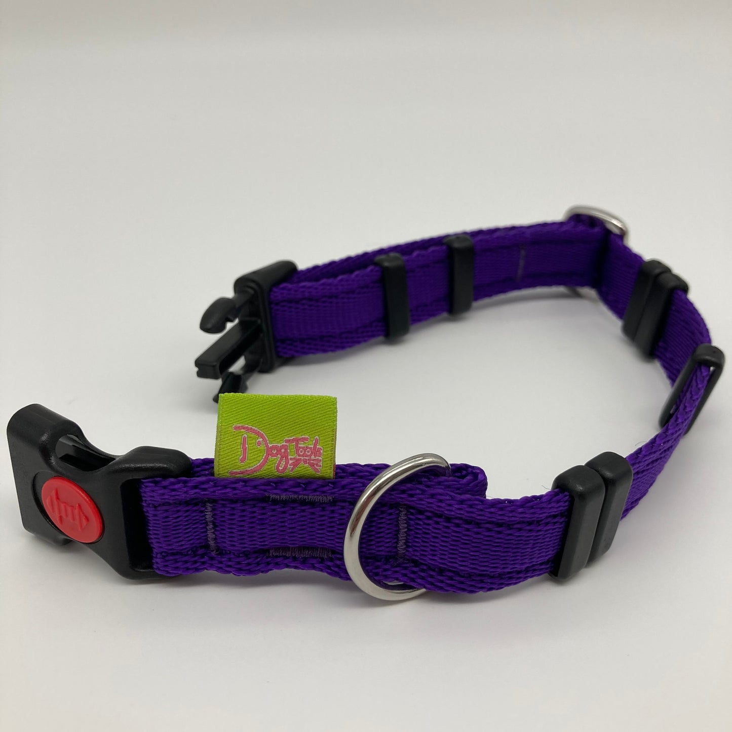 purple collar displayed on a white surface, unlocked, showing the black lock, stainless steel ring, the black loops and the applegreen DogTools label