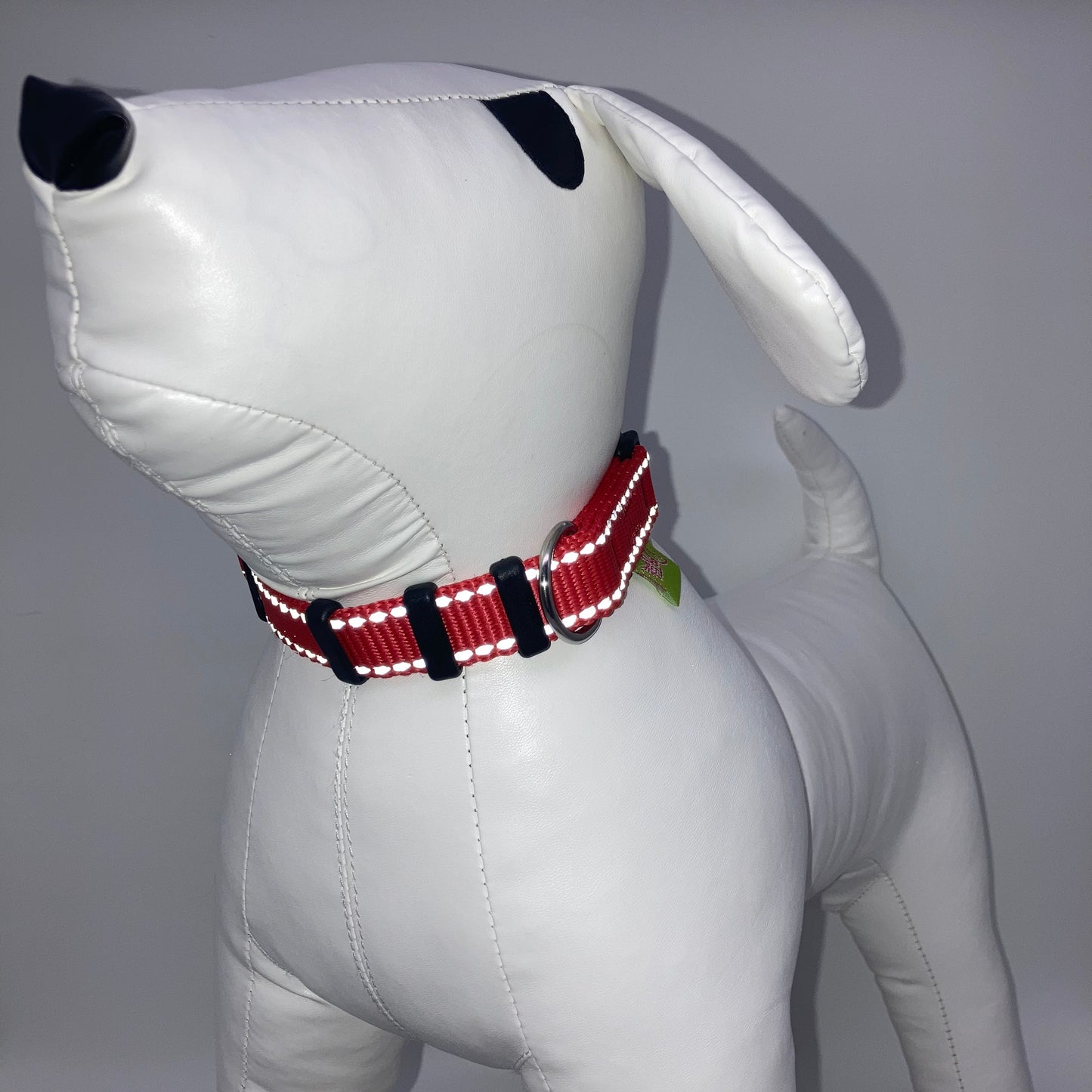 red collar with light reflecting stitches displayed on a stuffed toy (dog), from the front of the dog, showing its head and torso