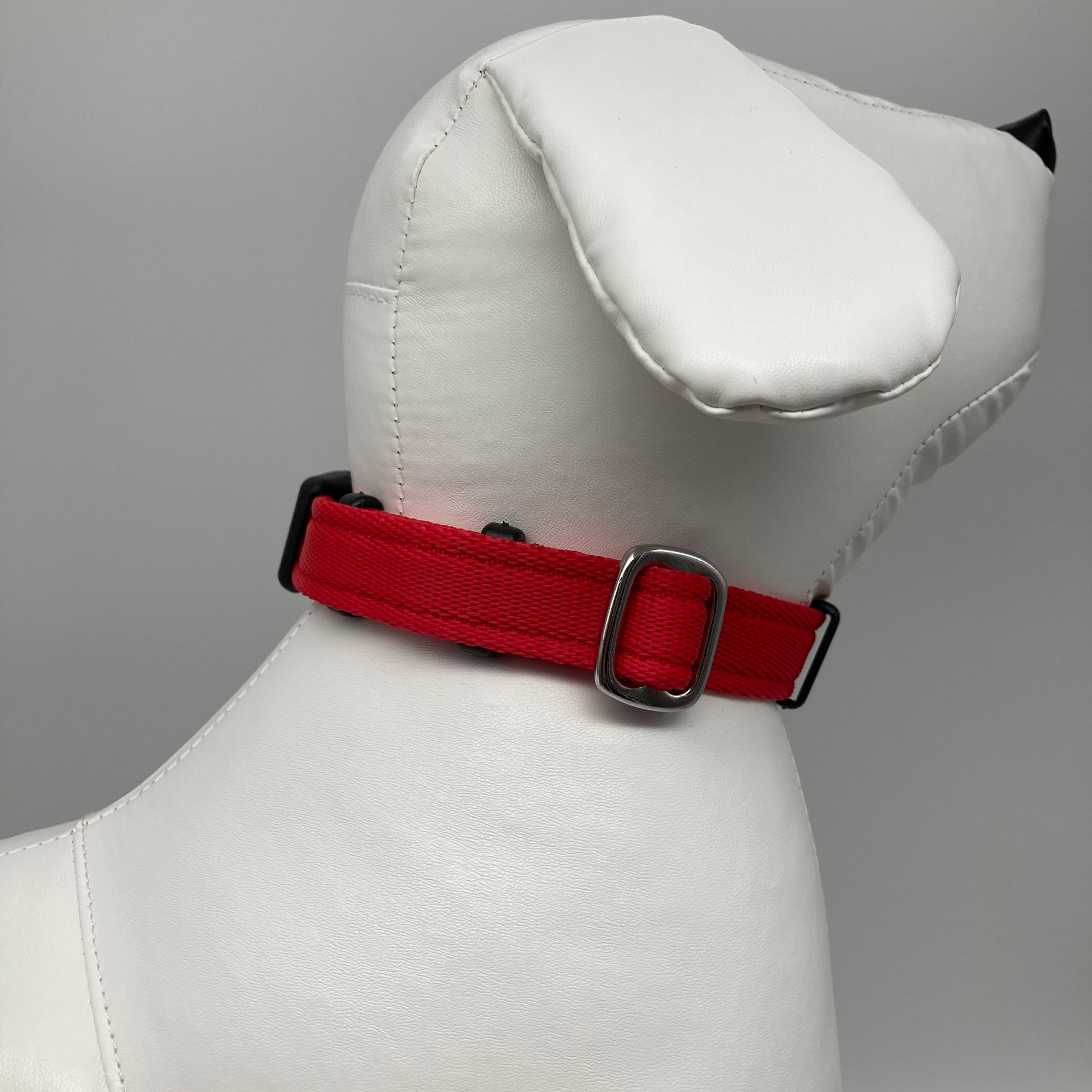 red collar displayed on a stuffed toy (dog), showing the back of the head and the collar from behind