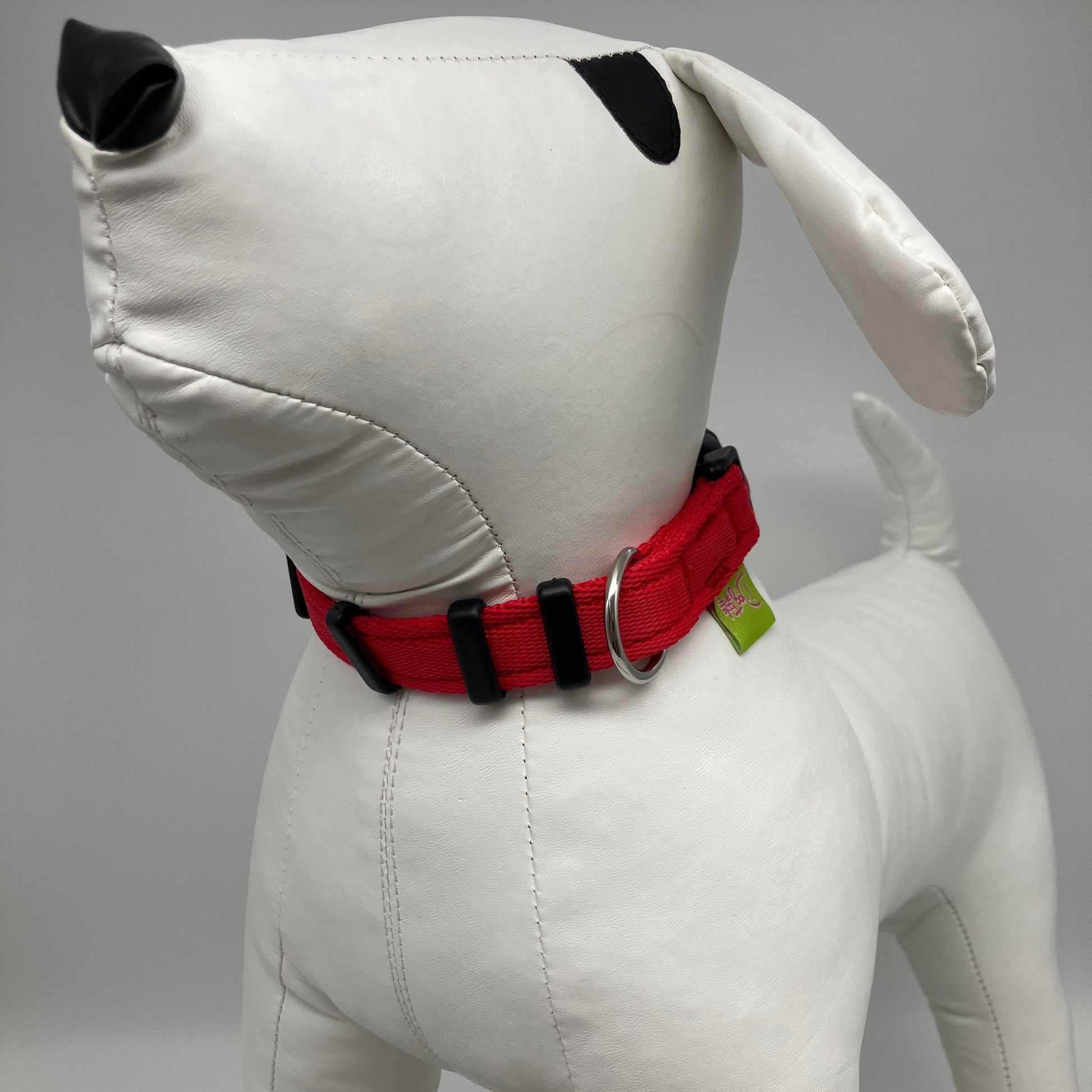 red collar displayed on a stuffed toy (dog), from the front of the dog, showing its head and torso