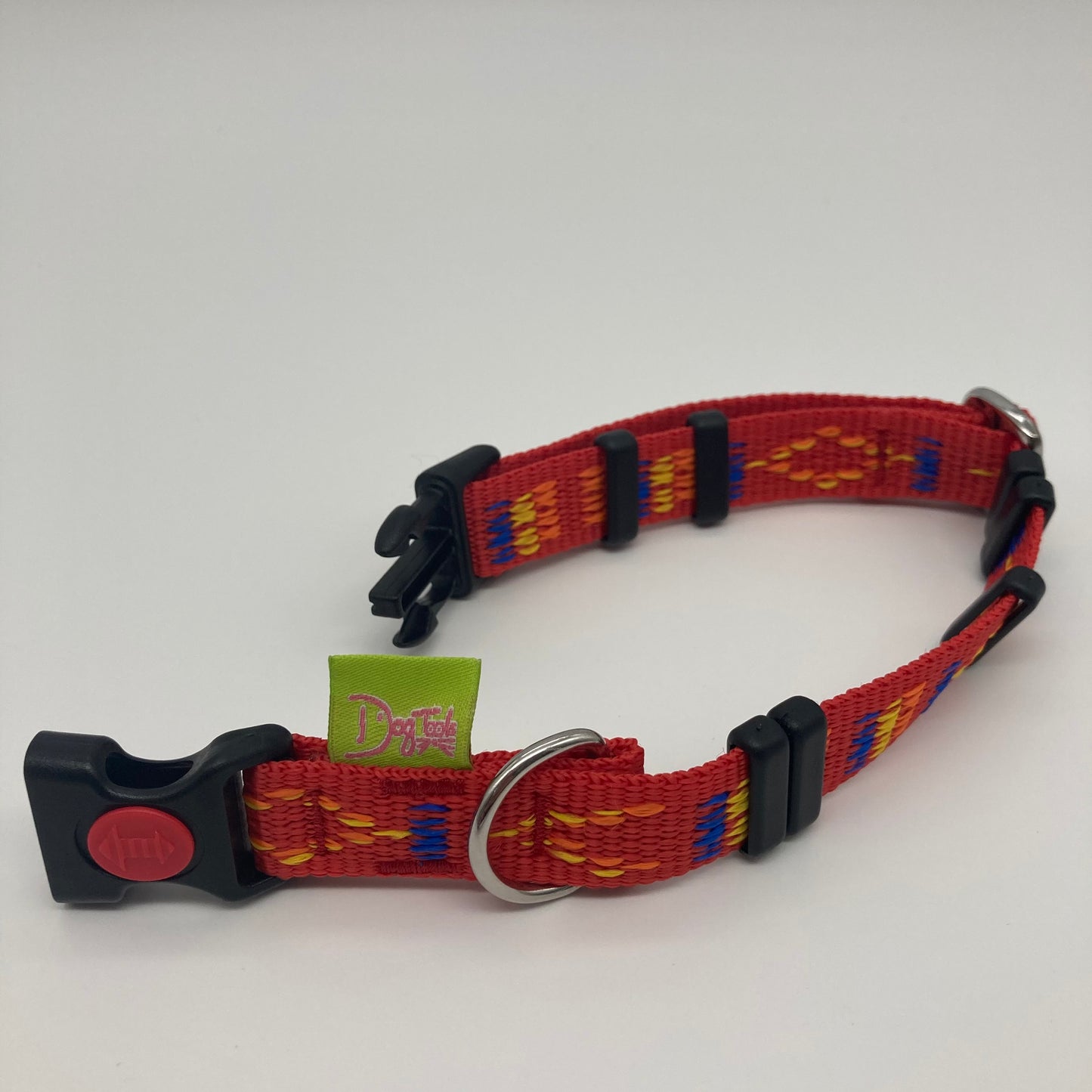 red Stitch (red fabric with print in 3 colors, yellow, orange and blue) collar displayed on a white surface, unlocked, showing the black lock, stainless steel ring, the black loops and the applegreen DogTools label